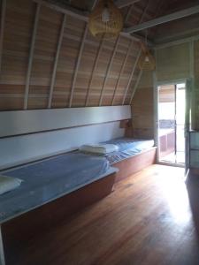 two beds in a room with a wooden floor at Arista Lakey Peak House in Huu