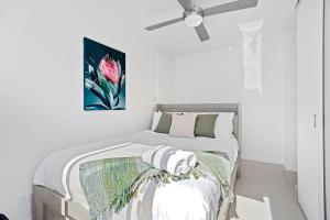 a white bedroom with a bed and a ceiling fan at 2 Welcome To Windsor 2br 2ba Pkg in Perth