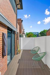 a patio with a green chair on a wooden deck at 2 Welcome To Windsor 2br 2ba Pkg in Perth