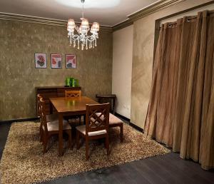 a dining room with a table and chairs and a chandelier at Luxury Modern Appartment in New Cairo in Cairo