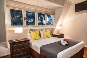 a bedroom with a bed with two lamps and windows at Cottonwood Beachfront in Oak Beach