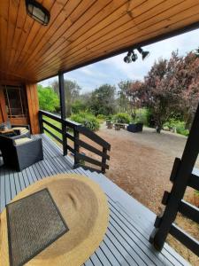 a wooden deck with a bench and a table at The Beach Cabin in Fingal