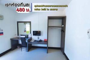 an office with a desk with a computer and a mirror at โรงแรมบาบาราย in Si Sa Ket