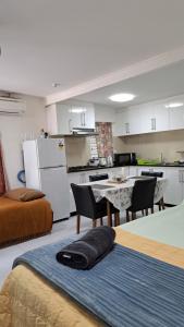 a room with a kitchen and a table with chairs at Mead Road Homestay Tours & Transfers Studio Flat 2 in Suva