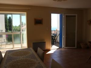 a living room with a door open to a balcony at Appartement Banyuls-sur-Mer, 3 pièces, 5 personnes - FR-1-309-58 in Banyuls-sur-Mer