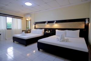 塔比拉蘭的住宿－道戴夢得餐廳及酒店，酒店客房,配有两张带白色床单的床
