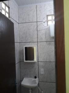 ein Bad mit einem Waschbecken und einem Spiegel in der Unterkunft HOSPEDAGEM DA ROSE 3 in Marataizes
