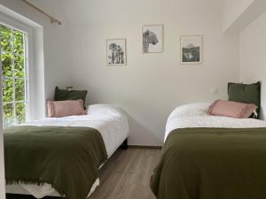 a bedroom with two beds with green and white sheets at Gîte Thoiry, 4 pièces, 6 personnes - FR-1-527-6 in Thoiry