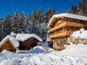 a log cabin covered in snow with trees in the background at Large hut in the Pinzgau with a great view and its own sauna hut in Dorf