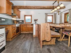 a kitchen with wooden cabinets and a wooden table at Large hut in the Pinzgau with a great view and its own sauna hut in Dorf