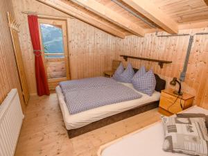 a bedroom with a bed in a wooden room at Cozy hut in Pinzgau with Finnish sauna in Dorf