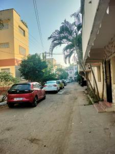 eine Straße mit am Straßenrand geparkten Autos in der Unterkunft SRI SANKARA VILLAS -- Aditya Heritage in Kumbakonam