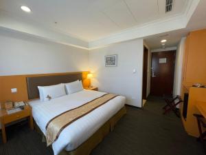 a bedroom with a large bed in a hotel room at Fuward Hotel Tainan in Tainan