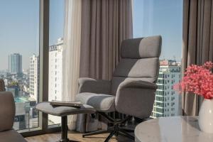 a living room with a chair and a large window at Everland Hotel in Danang
