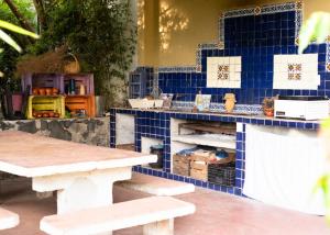 馬利納爾科的住宿－Hostal Tribu Malinalco，蓝色瓷砖柜台,配有两张桌子和长凳