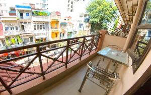 einen Balkon mit einem Tisch und Stadtblick in der Unterkunft Riverside Hotel Phnom Penh in Phnom Penh