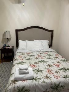 Una cama con colcha floral y una toalla. en Sanford Lake Mary Quiet Rooms, en Sanford