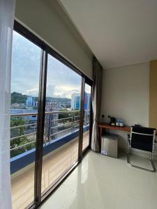 a room with a balcony with a chair and a window at Erbe Style Jayapura Papua By Horison in Jayapura