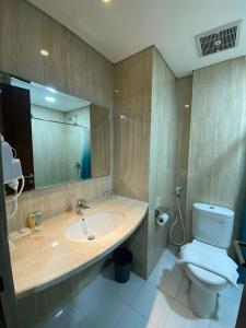 a bathroom with a sink and a toilet and a mirror at Erbe Style Jayapura Papua By Horison in Jayapura