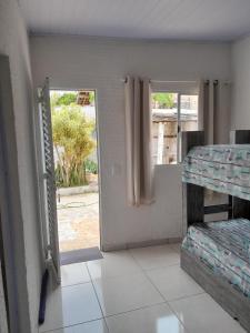 a room with a door open to a bedroom with bunk beds at Pousada do Forte in Praia Grande