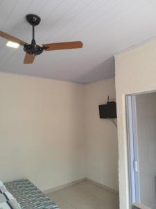 um ventilador de tecto num quarto com uma cama em Pousada do Forte na Praia Grande