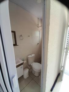 a small bathroom with a toilet and a sink at Pousada do Forte in Praia Grande