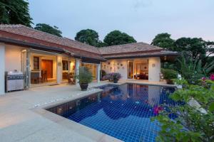 a villa with a swimming pool in front of a house at Katamanda villa Moon 3 Bed seaview villa in Kata Beach