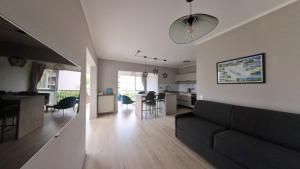 uma sala de estar e de jantar com um sofá e uma cozinha em Moana Beach Apartment em Noumea