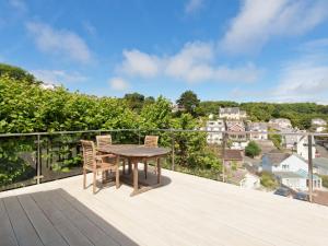 a wooden deck with a table and chairs on a balcony at Rockmount 1 in Salcombe