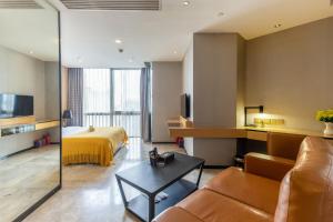 un soggiorno con un divano e un letto di Yoyo Apartment Jiedeng Metropolis Branch, Beijing Road a Canton