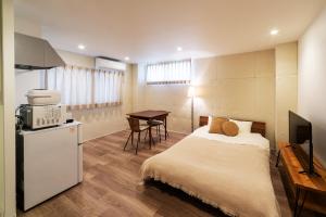 een slaapkamer met een bed en een keuken met een tafel bij TOGOSHI 568 STAY Togoshi Ginza in Tokyo