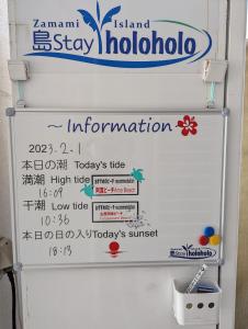 a white refrigerator with a sign on top of it at Shima Stay holoholo in Zamami