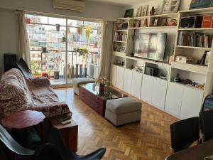 sala de estar con sofá, silla y ventana en Habitación individual en departamento compartido, barrio Recoleta en Buenos Aires