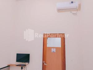 a room with a door and a heater and a television at Siliwangi Guest House Syariah Tasikmalaya Mitra RedDoorz in Tasikmalaya