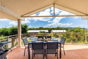 a dining table and chairs on a patio with a view at 74A Sergeant Baker Drive comfortable duplex with beautiful distant water views in Corlette