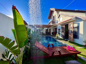 NGÀI Villa في Phu Yen: حديقة خلفية مع مقعد خشبي بجوار منزل