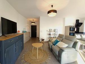 een woonkamer met een bank en een tv bij Appartement Aix-les-Bains, 3 pièces, 4 personnes - FR-1-555-82 in Aix-les-Bains