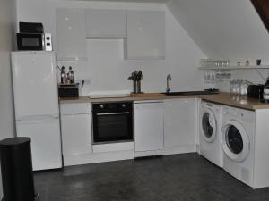 a kitchen with white cabinets and a washer and dryer at Appartement Le Palais, 3 pièces, 4 personnes - FR-1-418-226 in Le Palais