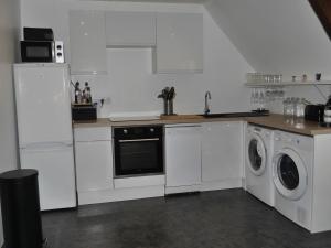a kitchen with white cabinets and a washer and dryer at Appartement rénové au centre du Palais, proche plage et commodités - FR-1-418-226 in Le Palais +6 photos