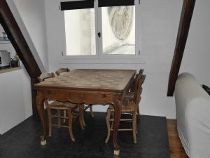 - une table et des chaises dans une chambre avec fenêtre dans l'établissement Appartement Le Palais, 3 pièces, 4 personnes - FR-1-418-226, au Palais