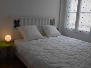 - une chambre avec un lit blanc avec deux oreillers et une fenêtre dans l'établissement Appartement Le Palais, 3 pièces, 4 personnes - FR-1-418-225, au Palais