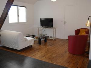 ein Wohnzimmer mit einem weißen Sofa und einem TV in der Unterkunft Appartement Le Palais, 3 pièces, 4 personnes - FR-1-418-226 in Le Palais