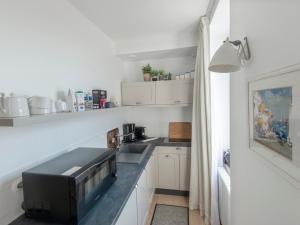 een kleine keuken met een wastafel en een magnetron bij Studio Sauzon, 1 pièce, 2 personnes - FR-1-418-227 in Sauzon