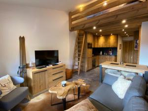 a living room with a couch and a tv and a table at Appartement La Clusaz, 2 pièces, 6 personnes - FR-1-437-99 in La Clusaz