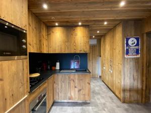 a kitchen with wooden walls and a sink and a stove at Appartement La Clusaz, 2 pièces, 6 personnes - FR-1-437-99 in La Clusaz