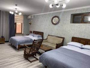 Habitación de hotel con 2 camas y sofá en Cinzano Complex, en Samarkand