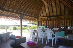 eine Terrasse mit einem Tisch und Stühlen in einem Pavillon in der Unterkunft Vai Iti Lodge in Afaahiti
