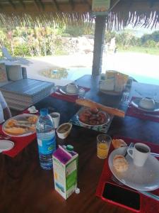 una mesa cubierta con platos de comida y bebida en Vai Iti Lodge, en Afaahiti