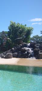 a beach with rocks and water and trees at Vai Iti Lodge in Afaahiti +22 photos