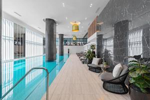 a hotel lobby with a swimming pool and chairs at Lumina Suites in Melbourne